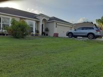 One story home with a two car garage and a landscaped lawn at 924 Derbyshire Dr, Kissimmee, FL 34758