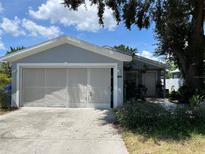 Gray house with a two-car garage and well-maintained landscaping at 1323 Kory St, Kissimmee, FL 34741