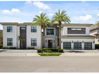 Luxury home with a three-car garage and palm trees at 350 Muirfield Loop, Reunion, FL 34747