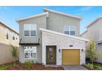 Modern two-story house with light gray siding and a yellow garage door at 9119 Sommerset Hills Dr, Davenport, FL 33896