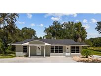 Newly renovated house with gray exterior and large windows at 8941 E County Road 466, The Villages, FL 32162