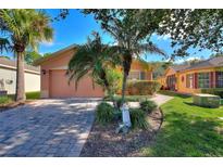 Charming house with a paved driveway and lush landscaping at 384 Grand Canal Dr, Poinciana, FL 34759