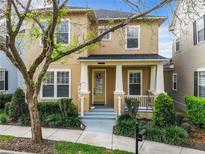 Two-story tan house with front porch and landscaping at 1134 Tapestry Dr, Celebration, FL 34747