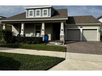 Two-story house with gray siding, two-car garage, and front porch at 3253 Wauseon Dr, Saint Cloud, FL 34772