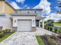 Two-story townhome with attached garage and landscaped yard at 7901 Putting Green Way, Reunion, FL 34747