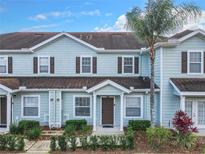 Light blue two-story townhome with dark brown accents at 5362 Diplomat Ct # 103, Kissimmee, FL 34746