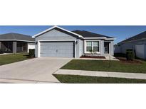 Gray house with a two-car garage and well-manicured lawn at 305 Cascara Ln, Auburndale, FL 33823