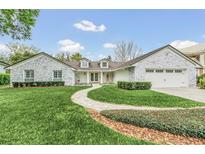 Stunning curb appeal! This home features a stone facade, lush landscaping, and a paved walkway at 7920 Summer Ridge Pl, Orlando, FL 32819