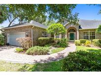Brick home with a landscaped lawn, walkway, and attached garage at 840 Coach Lamp Ct, Sanford, FL 32771