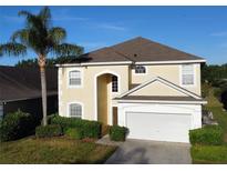 Two-story house with tan exterior, gray roof, and attached garage at 1821 Morning Star Dr, Clermont, FL 34714