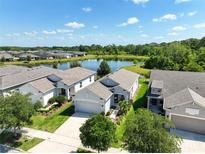 Community view showcasing homes around a pond at 3424 Sagebrush St, Harmony, FL 34773