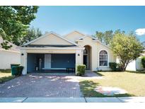House exterior, featuring a two-car garage and landscaped lawn at 2726 Randal Way, Kissimmee, FL 34743