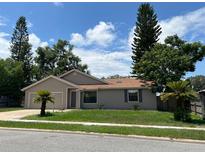 Tan one-story house with a two-car garage and landscaping at 866 Crows Bluff Ln, Sanford, FL 32773