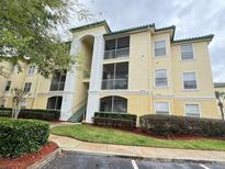 Two-story condo building with manicured landscaping at 8826 Dunes Ct # 207, Kissimmee, FL 34747
