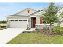 One-story home with stone accents and a two-car garage at 151 Bull Frog Ln, Umatilla, FL 32784