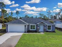 Newly built home with a two-car garage and landscaping at 16619 Sw 31St Cir, Ocala, FL 34473