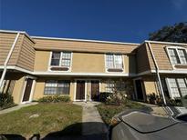 Tan two-story townhouse with a manicured lawn at 6062 N Village Cir # Ge, Orlando, FL 32822