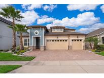Two-story house with a three-car garage and landscaped front yard at 2518 Fontaine Dr, Kissimmee, FL 34741