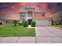 Two story house with attached garage and manicured lawn at 573 Viola Dr, Davenport, FL 33837