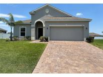 Single-story house with a two-car garage and a paved driveway at 2757 Creekmore Ct, Kissimmee, FL 34746