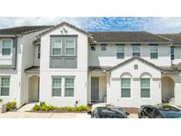 Two-story townhome with gray door and landscaping at 301 Captiva Dr, Davenport, FL 33896