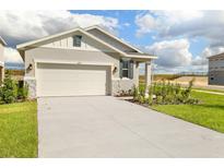 Front view of charming house with a two-car garage and landscaped yard at 6357 Clover St, Lake Hamilton, FL 33851