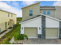 Modern two-story townhome with a two-car garage and paver driveway at 523 Ocean Course Ave # 523, Davenport, FL 33896