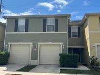 Two-story townhome with a two-car garage and neutral exterior at 624 Cresting Oak Cir # 32, Orlando, FL 32824