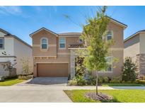 Two-story home with a neutral facade and landscaping at 1770 Sawyer Palm Pl, Kissimmee, FL 34747