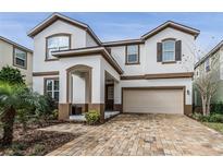 Two-story house with a beige garage and brick driveway at 1754 Caribbean View Ter, Kissimmee, FL 34747