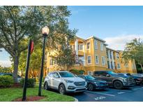 Condo building exterior with parking and landscaping at 3593 Conroy Rd # 437, Orlando, FL 32839