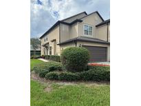 Two-story townhome with landscaping and attached garage at 701 Virtuoso Ln # 81, Orlando, FL 32824
