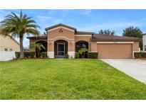 One-story house with a two-car garage and palm trees at 840 Crooked Branch Dr, Clermont, FL 34711
