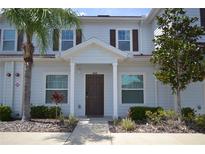 Two-story home with brown door and landscaping at 3208 Cupid Pl, Kissimmee, FL 34747
