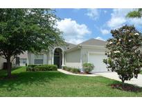Single-story home with a two car garage and lush landscaping at 648 Copeland Dr, Haines City, FL 33844