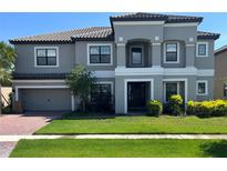 Two-story house with gray exterior, three-car garage, and manicured lawn at 2901 Agostino Ter, Kissimmee, FL 34746