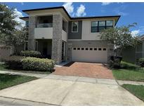 Two story house with stone accents and a brick driveway at 2414 Fenetre Ln, Kissimmee, FL 34741