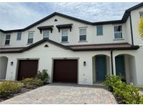 Two-story townhome with two-car garage and teal door at 4422 Small Creek Rd # 72, Kissimmee, FL 34744