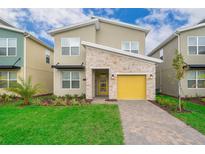 Two-story home with a yellow garage door and landscaped yard at 2744 Bookmark Dr, Kissimmee, FL 34746