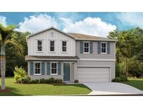 Two story home with gray and white siding, teal shutters, and two-car garage at 1618 Sugarbelle Cir, Mascotte, FL 34753