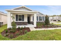 A charming one-story house with stone accents and a covered porch at 2900 Sharp Rd, Kissimmee, FL 34744