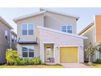 Modern two-story home with a yellow garage door and stone accents at 3028 Protagonist St, Kissimmee, FL 34746