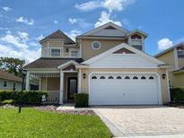 Two-story house with a charming front porch and landscaped yard at 2143 Victoria Dr, Davenport, FL 33837