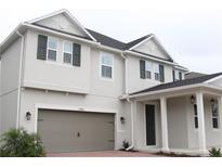 Two-story home with gray siding, gray garage door, and white columns at 11460 Chateaubriand Ave, Orlando, FL 32836