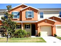 Two-story townhome with orange exterior and teal accents at 5144 Adelaide Dr, Kissimmee, FL 34746
