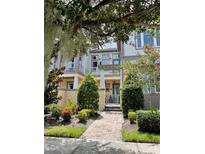 Charming townhome with landscaped walkway and lush greenery at 8079 Nemours Pkwy, Orlando, FL 32827