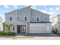 Modern two-story house with gray siding and two-car garage at 1735 Oak Blossom Dr, Davenport, FL 33837