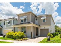 Two story house with light beige siding and dark roof at 8963 Amelia Downs Trl, Kissimmee, FL 34747