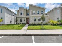 Modern two-story home with stone accents and landscaped lawn at 4514 Narrative Ln, Kissimmee, FL 34746