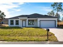 Newly constructed one-story home with a modern design, two-car garage, and spacious lawn at 1306 Congo Dr, Poinciana, FL 34759